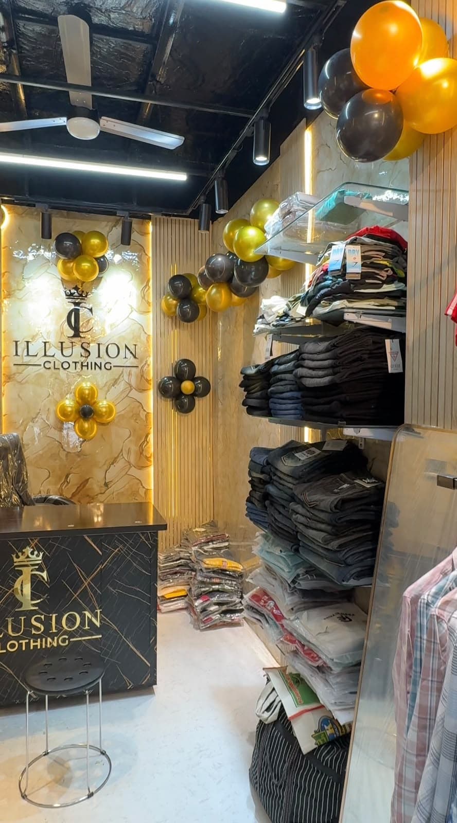 Shelves of folded denim and shirts at Illusion Clothing