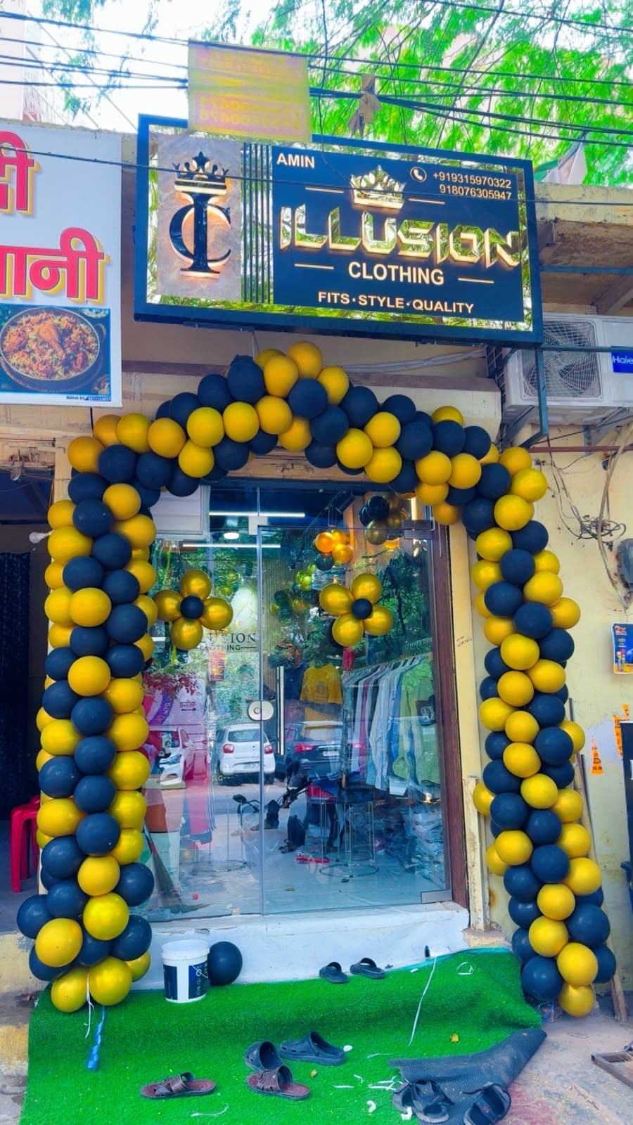 Illusion Clothing store entrance with black and gold balloon arch
